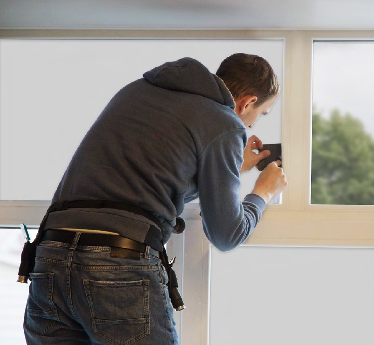 Technician precisely installing smart film on a glass partition